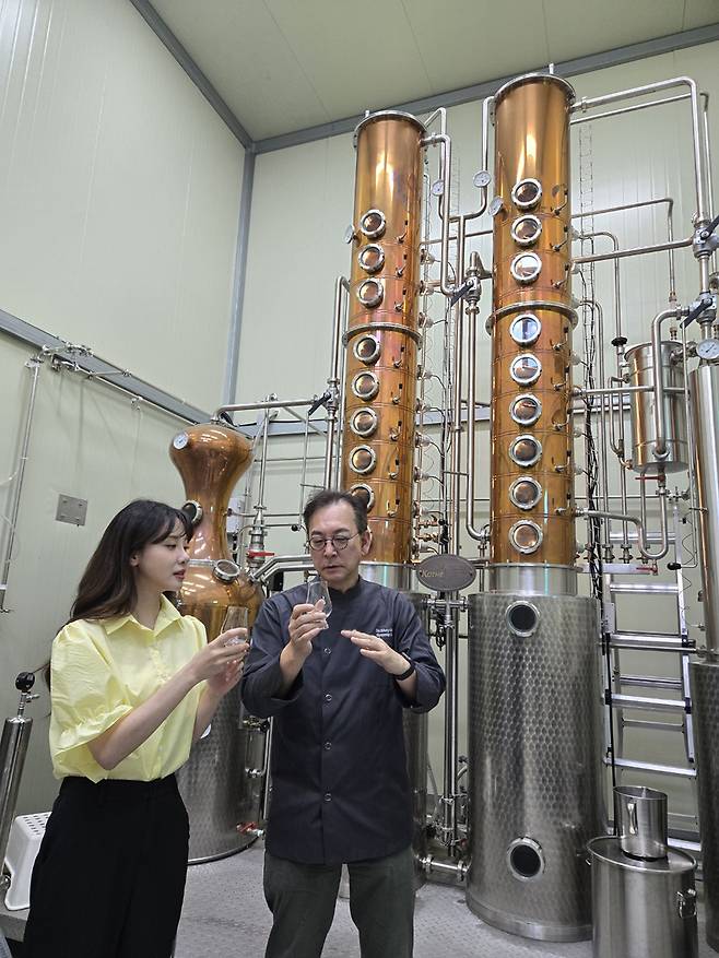 방송인 김민아와 오규섭 온 증류소 대표가 증류기를 통해 바로 나온 연연 25의 원주(알코올 90도 이상)를 맛보고 있다. 온 증류소 제공