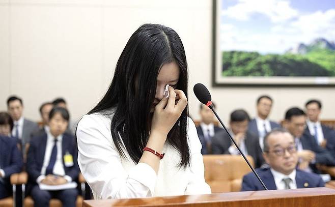 뉴진스 하니가 지난 2024년 10월 서울 여의도 국회에서 열린 환경노동위원회 국정감사에서 눈물을 닦고 있다. 연합