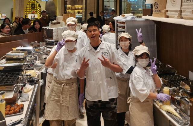 호두과자 브랜드 부창제과 매장에서 배우 이장우가 직원들과 기념 사진을 촬영하고 있다. 사진 제공=FG