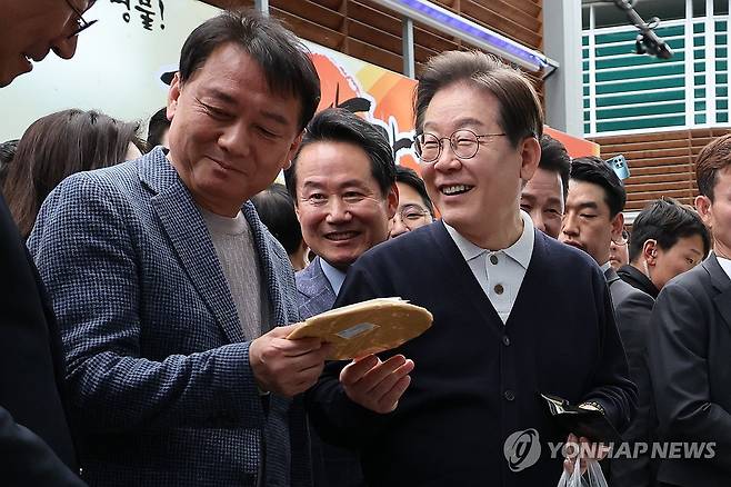 영월 장터 찾은 이재명 후보 (영월=연합뉴스) 김주성 기자 = 더불어민주당 이재명 대선 후보가 '골목골목 경청투어' : 단양8경편'에 나선 4일 강원도 영월군 영월서부시장에서 엿을 사며 공동선대위원장을 맡은 이광재 전 강원지사와 대화하고 있다. 2025.5.4 utzza@yna.co.kr
