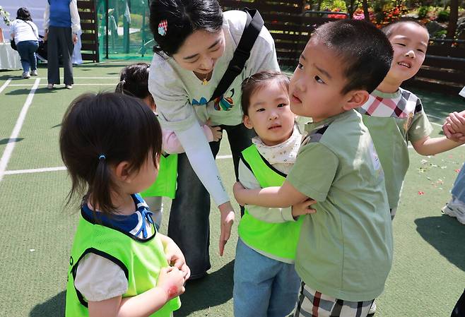 지난달 30일 오전 어린이날을 앞두고 경기 남양주시 시립효성솔빛길어린이집 풋살장에서 하나어린이집과 효성솔빛길어린이집이 함께 연 ‘소소한 소풍’에서 하나 성재(오른쪽 둘째)가 솔빛길 루다를 안아주고 있다. 김혜윤 기자 unique@hani.co.kr