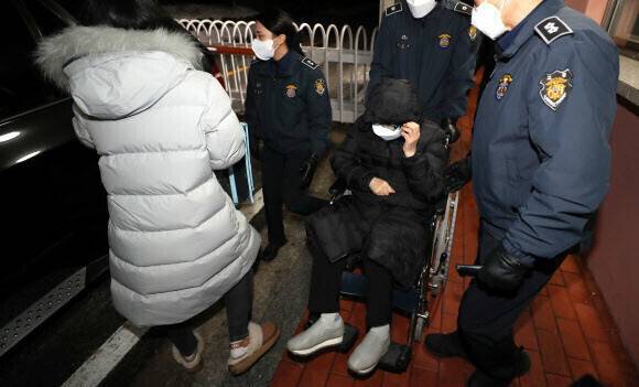 최서원(가운데 휠체어 탄 이)씨가 2022년 12월 26일 밤 형 집행정지로 일시 석방돼 청주교도소를 나서고 있다.연합뉴스