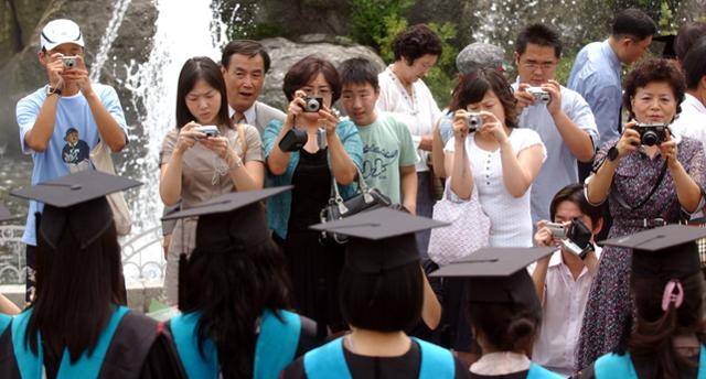 2005년 8월 17일 학위수여식이 열린 서울 경희대에서 졸업생 가족들이 각자 디지털 카메라를 들고 사진을 찍고 있다. 한국일보 자료사진