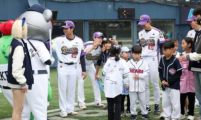 어린이 야구팬들이 어린이날 미니 올림픽 이벤트를 마친 뒤 선수들과 기념사진을 찍고 있다. 뉴시스