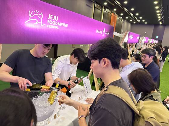 Visitors at the Jeju Food & Wine Festival last year take samples of wine at Jeju Shinhwa World in Jeju. [JOONGANG PHOTO]