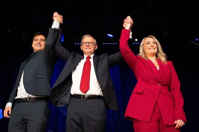 3일(현지시간) 호주 시드니 캔터베리-헐스톤 파크 RSL 클럽에서 열린 노동당 선거의 밤 행사에서 앤서니 앨버니지 호주 총리(가운데)가 연인 조디 헤이든(오른쪽), 자신의 아들 네이선과 함께 손을 번쩍 들며 총선 승리를 자축하고 있다. [EPA = 연합뉴스]