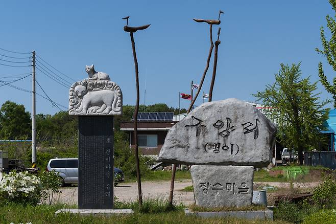 구양리 마을 표지석. 표지석 사이로 마을회관 옥상에 설치한 태양광 집열판이 보인다. [사진=전형민 기자]