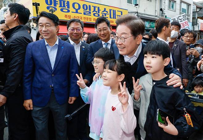 이재명 더불어민주당 대선 후보가 5일 '2차 골목골목 경청투어'로 찾은 경기 양평군 양평시장에서 어린이들과 기념촬영을 하고 있다.  뉴스1