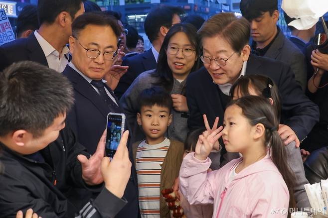 (진천=뉴스1) 안은나 기자 = 이재명 더불어민주당 대통령 후보가 2차 골목골목 경청투어에 나선 5일 오후 충북 진천군의 혁신도시 상가를 찾아 다자녀 가정과 기념 촬영하고 있다. 2025.5.5/뉴스1  Copyright (C) 뉴스1. All rights reserved. 무단 전재 및 재배포,  AI학습 이용 금지. /사진=(진천=뉴스1) 안은나 기자