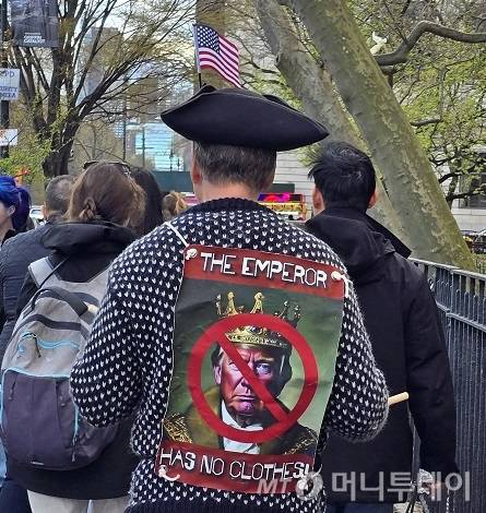 도널드 트럼프 미국 대통령의 정책을 반대하는 시민들이 지난 19일 미국 뉴욕 맨해튼에서 시위를 벌이고 있다. 시위 참가자가 등에 맨 팻말에 '트럼프는 벌거벗은 임금님'이라는 문구가 보인다. /사진=심재현 특파원