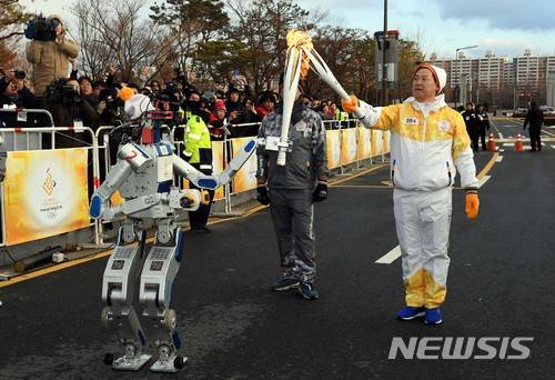 【대전=뉴시스】 사진공동취재단 = 11일 대전 유성구 카이스트에서 로봇을 이용한 ICT 스페셜 성화 봉송이 열려 휴머노이드 로봇 휴보가 성화를 봉송하고 있다. 2017.12.11. photo@newsis.com