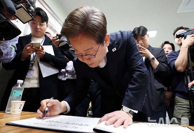 [여주=뉴시스] 조성봉 기자 = 민심을 청취하는 '경청 투어'에 나선 이재명 더불어민주당 대선후보가 5일 경기 여주시 구양리 새마을식당에서 방명록을 쓰고 있다.2025.05.05. suncho21@newsis.com