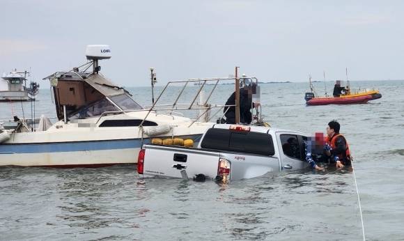 해경이 바다에 침수되고 있는 픽업트럭에서 운전자를 구조하고 있다. 인천해경서 제공