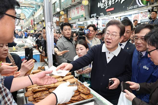5월4일, 더불어민주당 이재명 대선 후보가 ‘골목골목 경청투어 : 단양8경편’에 나서 충북 단양군 단양구경시장에서 떡갈비를 사먹으면서 지역화폐를 사용하고 있다. ⓒ연합뉴스
