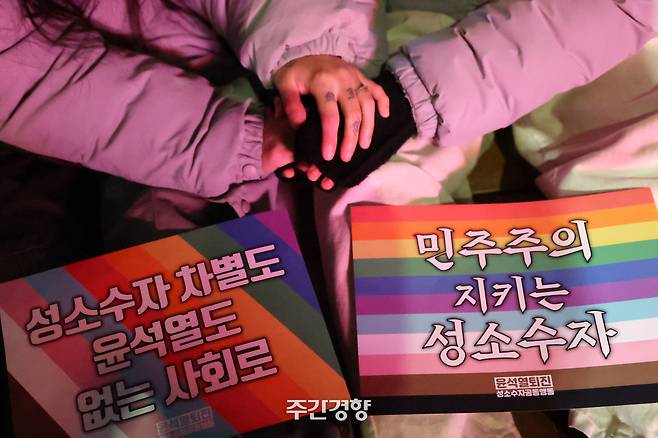 지난해 12월 25일 서울 중구 국가인권위원회 인근에서 열린 ‘윤석열 퇴진하고 평등세상으로’ 집회에서 참가자들이 손을 잡고 있다. 한수빈 기자