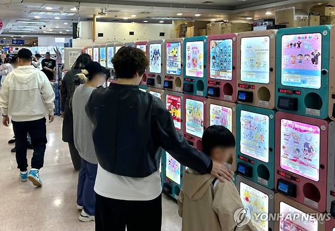 어떤 가챠를 해볼까 (서울=연합뉴스) 김유진 인턴기자 = 지난달 27일 오후 서울 서초구의 국제전자센터에서 한 여성이 아이와 함께 가챠(캡슐 토이)를 구경하고 있다. 2025.5.5