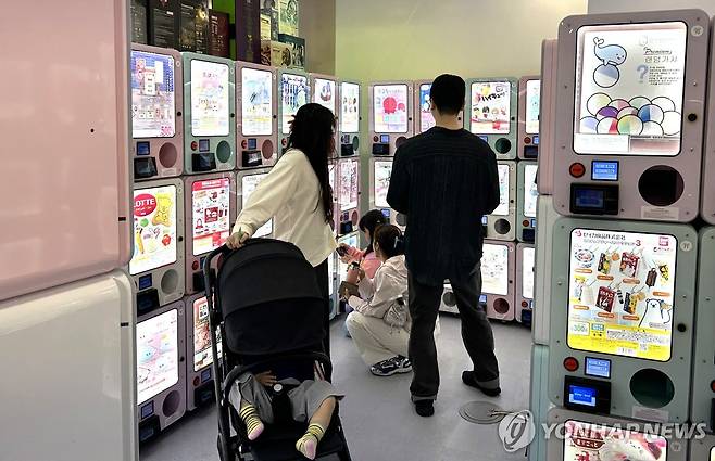 엄마 아빠도 가챠 삼매경 (서울=연합뉴스) 김유진 인턴기자 = 지난달 27일 오후 서울 서초구의 국제전자센터에서 한 부부가 유모차에 탄 아이와 함께 가챠(캡슐 토이)를 구경하고 있다. 2025.5.5