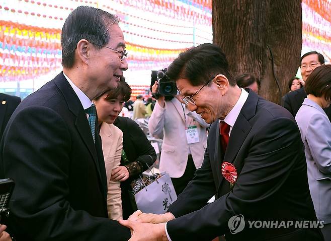 봉축법요식 마치며 인사하는 김문수 대선 후보와 한덕수 대선 예비후보 (서울=연합뉴스) 한상균 기자 = 국민의힘 김문수 대선 후보(오른쪽)와 무소속 한덕수 대선 예비후보가 5일 서울 종로구 조계사에서 열린 불기 2569년 부처님오신날 봉축법요식을 마친 뒤 악수하고 있다. 2025.5.5 xyz@yna.co.kr