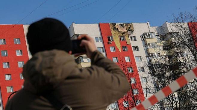 드론 공격을 받은 건물 사진을 찍는 사람