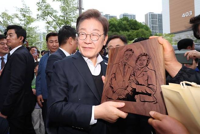 민심을 청취하는 '경청 투어'에 나선 이재명 더불어민주당 대선 후보가 5일 충북 진천군 혁신도시 거리에서 판화를 선물받고 있다. ⓒ뉴시스
