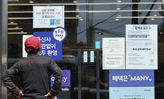 2일 서울 시내의 한 SK텔레콤 대리점 앞에서 한 소비자가 유심 재고 소진 및 유심보호서비스 관련 안내문을 살펴보고 있다. 연합뉴스