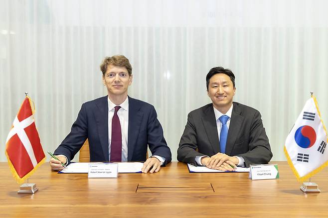 정기선 HD현대 수석부회장과 A.P. 몰러 머스크 로버트 머스크 우글라 의장이 '탈탄소 해운 기술 발전 및 글로벌 통합 물류 서비스 분야의 포괄적 협력 관계 구축을 위한 양해각서(MOU)'에 서명하고 있다. HD현대