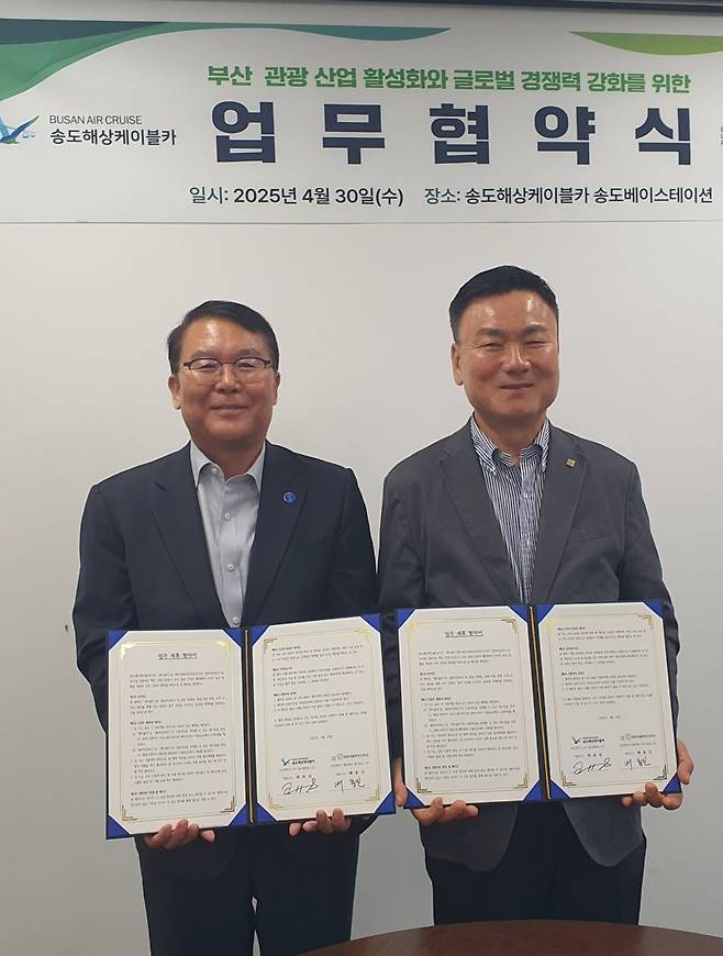 배종진 해운대블루라인(주) 대표(왼쪽)와 최효섭 (주)송도해상케이블카 대표가 업무협약서를 들고 포즈를 취하고 있다. 송도해상케이블카 제공