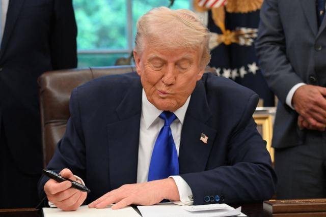 도널드 트럼프 미국 대통령이 5일 워싱턴 백악관 집무실에서 행정명령에 서명하고 있다. 워싱턴=AFP 연합뉴스