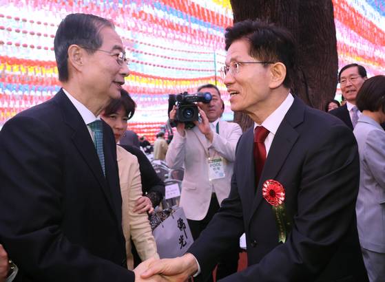 김문수 국민의힘 대선 후보와 한덕수 무소속 대선 예비후보가 5일 서울 종로구 조계사에서 열린 부처님오신날 봉축법요식에서 악수하고 있다. 대통령실사진기자단