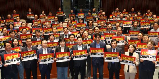 더불어민주당 박찬대 당 대표 직무대행 겸 원내대표(앞줄 가운데)와 의원들이 지난 4일 국회 비상 의원총회에서 ‘대선개입 대법원 규탄!’이 적힌 피켓을 들고 구호를 외치고 있다. 뉴시스