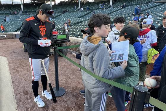 시카고 컵스와의 경기에 앞서 어린이들에게 사인볼을 선물하는 이정후(왼쪽). 로이터=연합뉴스