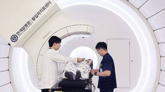 지난달 29일 오전 세브란스병원 중입자치료센터에서 이종윤씨가 치료 준비 중이다. 의료진이 치료에 앞서 이씨의 자세를 잡아주고 있다. 장진영 기자