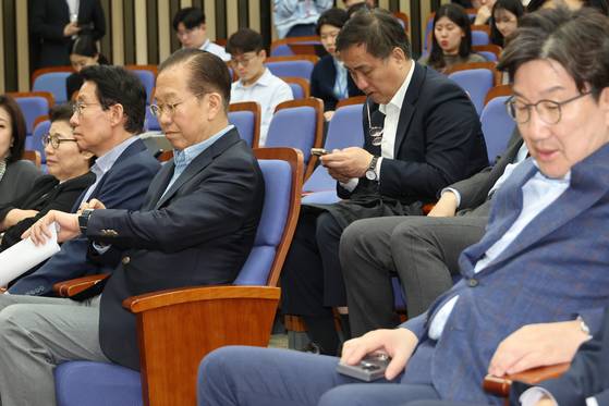 국민의힘 권영세 비상대책위원장이 6일 서울 여의도 국회에서 열린 의원총회에서 시계를 보고 있다.   권 비대위원장은 발언을 통해 한덕수 후보와의 단일화에 대해 "어떻게든 11일까지는 완료돼야 한다"고 말했다. 오른쪽은 권성동 원내대표. 연합뉴스