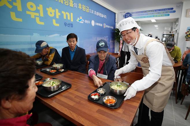 박병규 광주 광산구청장이 최근 광산구 ‘천원한끼’ 우산점을 찾은 손님들에게 콩나물국밥을 직접 제공하고 있다. 광산구 제공