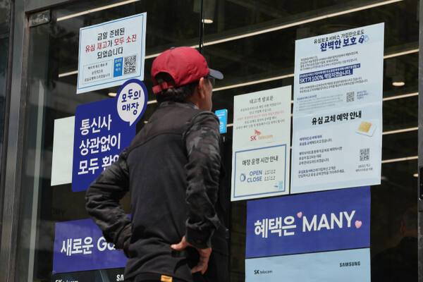 유심 재고 소진 및 유심보호서비스 관련 안내문을 살펴보고 있는 시민. 연합뉴스