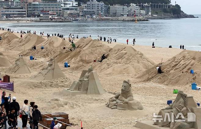 [부산=뉴시스] 하경민 기자 = 황금연휴 마지막 날인 6일 부산 해운대구 해운대해수욕장을 찾은 시민과 관광객들이 나들이를 즐기고 있는 가운데 백사장에는 모래작가들이 작품을 만들고 있다.해운대구는 오는 16~19일 '2025년 해운대 모래축제'를 개최한다. 올해 20주년을 맞은 모래축제는 '모래로 만나는 K-컬처'를 주제로 14명의 해외 모래 작가가 제작한 총 20여 개의 작품을 선보인다. 2025.05.06. yulnetphoto@newsis.com