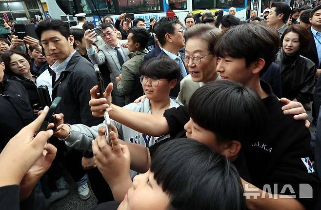 [옥천=뉴시스] 조성봉 기자 = 민심을 청취하는 '경청 투어'에 나선 이재명 더불어민주당 대선후보가 6일 충북 옥천군 옥천공설시장에서 어린이들과 셀카를 찍고 있다. 2025.05.06. suncho21@newsis.com