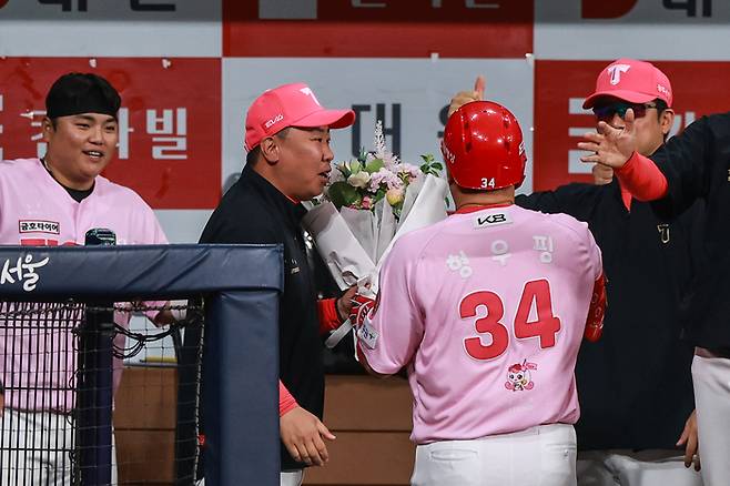 KIA 최형우(가운데)가 5일 고척스카이돔에서 열린 2025 KBO리그 키움전에서 개인 통산 400호 홈런을 터뜨린 후 더그아웃으로 돌아오자 이범호 감독(왼쪽 두 번째)이 꽃다발을 전하고 있다. 사진 | KIA 타이거즈