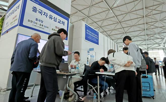 6일 오전 인천국제공항에 설치된 SKT 부스를 찾은 여행객들이 출국에 앞서 유심을 교체하고 있다. / 뉴스1