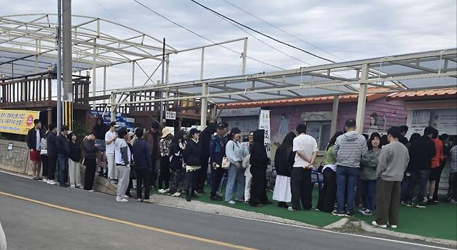 경남 통영 고메원 점포 앞에서 '고메원도넛'과 '고구마라떼'를 사려고 고객들이 줄을 서서 기다리고 있다.