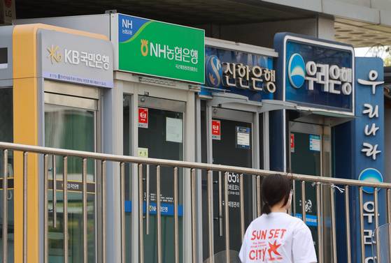 Automated teller machines for Korea's four major banks are lined on a street in Seoul on April 27. [YONHAP]
