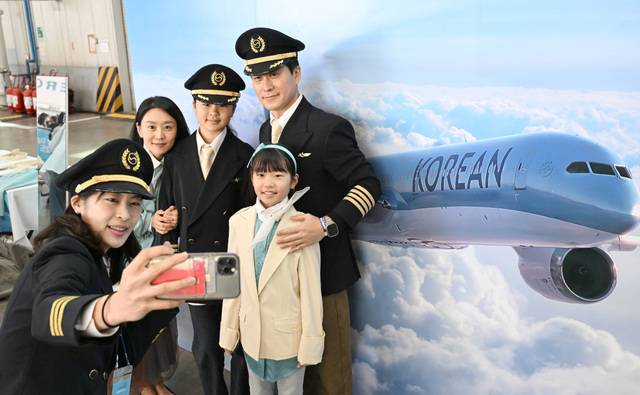 행사에 참가한 가족이 대한항공 항공기 사진을 배경으로 기념촬영을 하고 있다.