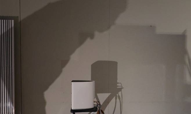 지난 2023년 12월 3일 서울 강남구 코엑스 컨퍼런스룸에서 열린 오디오엑스포서울 2023의 한 업체 부스에서 기기를 살피며 청음하는 관람객의 그림자가 벽면에 비치고 있다. 연합뉴스