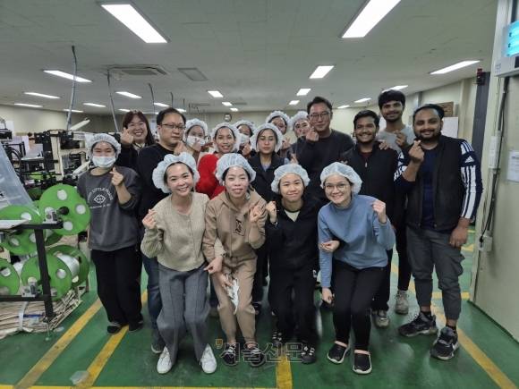 경기 파주에 있는 공장 대진씨앤씨에서 일하는 알라민(오른쪽 첫 번째)과 이엔, 정의석(둘째 줄 오른쪽 세 번째) 대표, 임승준 팀장 등 직원들이 6일 공장을 배경으로 활짝 웃으며 ‘손 하트’를 만들어 보이고 있다. 이곳의 이주노동자는 전체 직원의 절반 이상이며 그중에서도 5년 이상 근속한 직원은 80%에 달한다. 김우진 기자