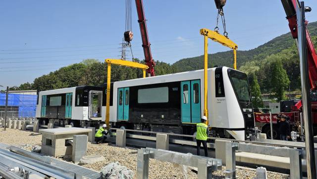 8일 양산선 차량기지에서 첫선을 보인 전동차를 크레인이 주행로에 내려놓고 있다. 김태권 기자 ktg660@