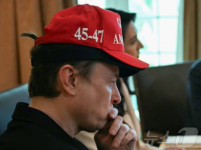 일론 머스크 미국 정부효율부(DOGE) 수장이 30일(현지시간) 워싱턴 백악관에서 도널드 트럼프 대통령 주재의 각료회의서 검은색 모자 위에 '미국 만'이라고 쓰인 빨간색 모자를 겹쳐 쓰고 참석하고 있다. 2025.05.01 ⓒ AFP=뉴스1 ⓒ News1 우동명 기자