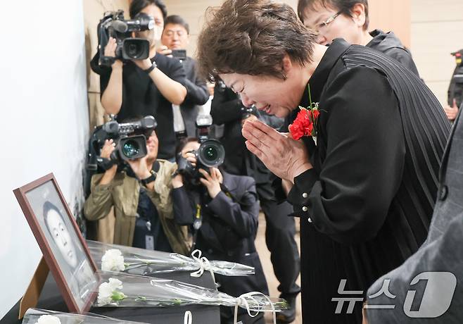 8일 서울 동작구 국방부유해발굴감식단에서 열린 6·25전사자 유해 얼굴복원 유가족 초청행사에서 故 송영환 일병의 딸인 송재숙 씨가 영정에 카네이션을 놓고 있다. 국방부 유해발굴감식단은 어버이날을 맞아 고인의 딸인 송재숙 씨를 국유단으로 초청, 유해를 바탕으로 완성한 2D 표준 영정과 감사패를 전달했다. 송 씨는 본인이 3살 때 세상을 떠난 아버지를 찾기 위해 2020년 직접 국유단을 방문, 유전자 시료를 제공했다. 2025.5.8/뉴스1 ⓒ News1 허경 기자
