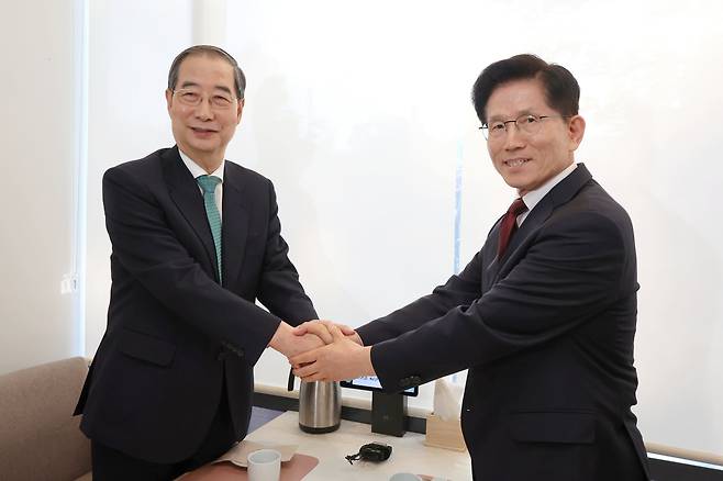 국민의힘 김문수 대선후보와 무소속 한덕수 대선 예비후보가 2025년 5월 7일 서울 종로구의 한 식당에서 후보 단일화 관련 회동을 하기 전 악수하고 있다. / 박성원 기자