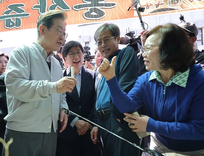 더불어민주당 이재명 대선 후보가 '골목골목 경청투어:국토종주편'에 나선 7일 정은경 총괄선대위원장과 함께 전북 진안군 새참거리 앞 인삼 가게에서 수삼을 먹어보고 있다. 연합뉴스