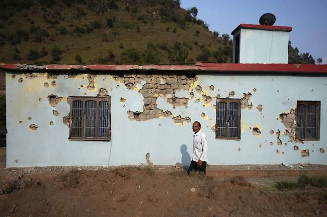 지난 7일 수요일, 인도 라조우리(Rajouri)에서 한 남성이 파키스탄의 포격으로 손상된 건물 옆을 지나가고 있다. 뉴시스 외신화상